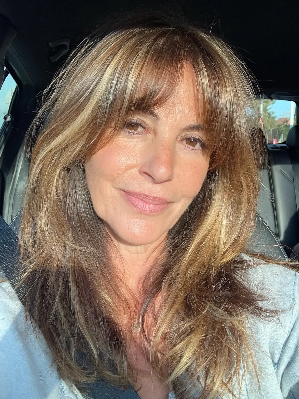 Long Wavy Layers with Curtain Bangs and Caramel Highlights